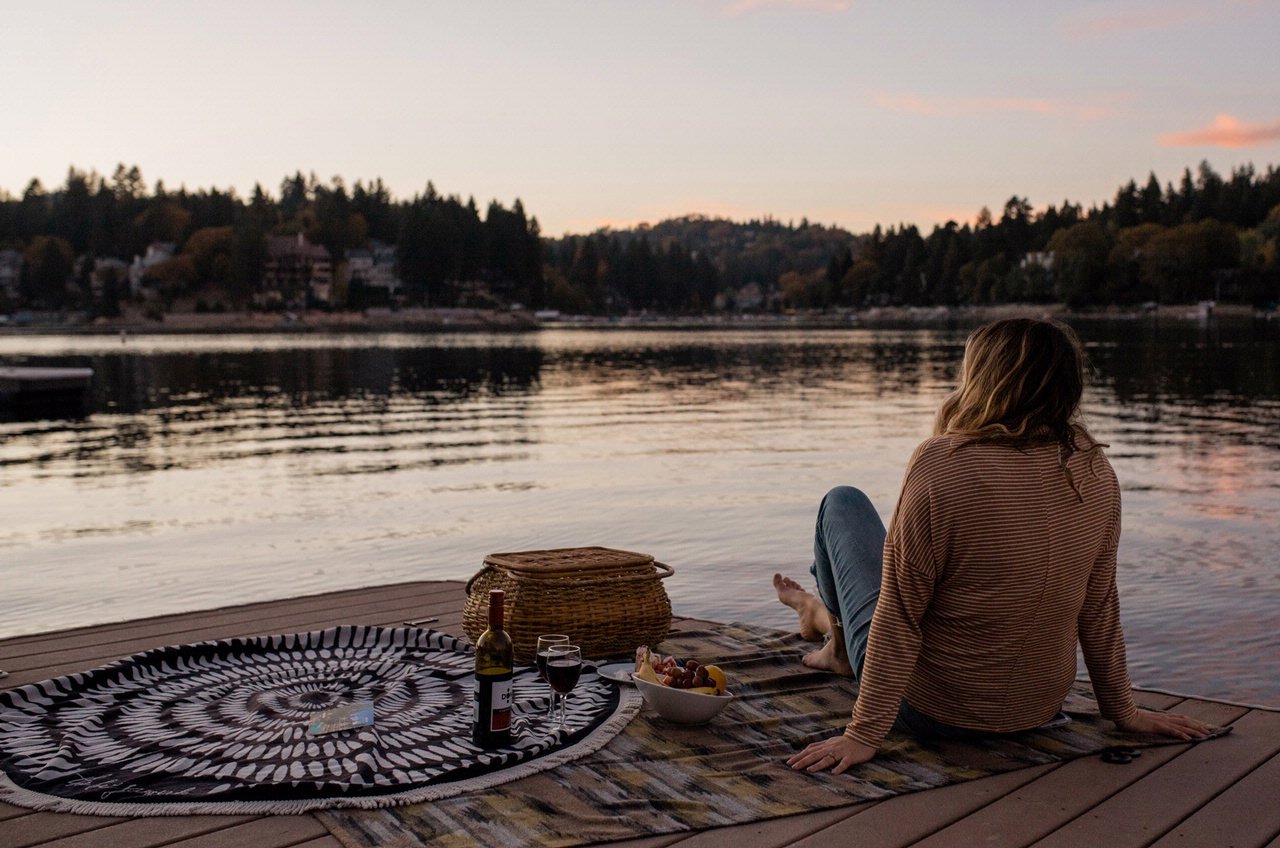 Mujer mirando el lago al atardecer